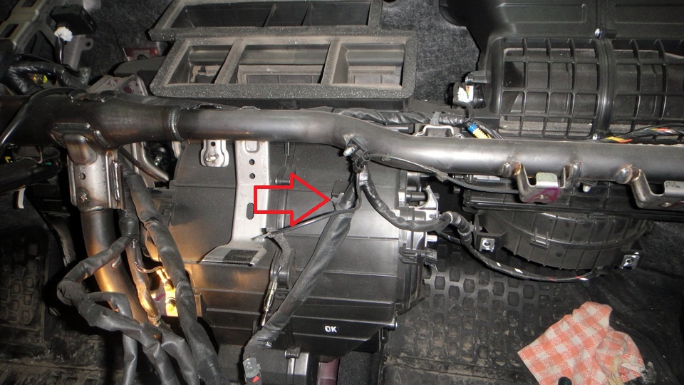 Отсоединить от корпуса отопителя держатель проводов между корпусом отопителя и панелью приборов на автомобиле Hyundai Solaris