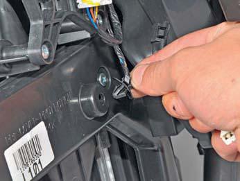 Отсоединить держатель проводов от крышки радиатора отопителя на автомобиле Hyundai Solaris