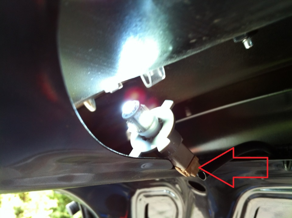 Отсоединить колодку проводов от разъема патрона освещения номерного знака на автомобиле Hyundai Solaris