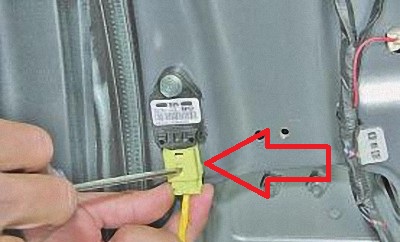 Отсоединить колодку проводов датчика бокового удара на автомобиле Hyundai Solaris