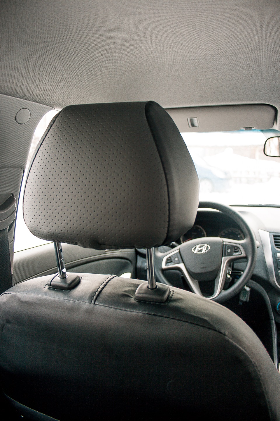 Поднятый подголовник переднего сиденья на автомобиле Hyundai Solaris 2010-2016