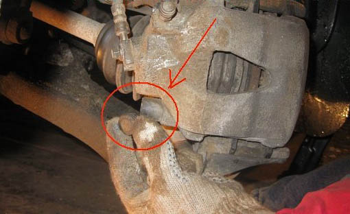 Снятие защитных колпачков с направляющих пальцев тормозного суппорта переднего колеса автомобиля Skoda Fabia I