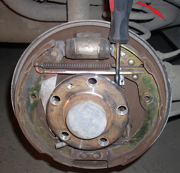Выведение колодки из барабана тормозного механизма заднего колеса автомобиля Skoda Fabia I