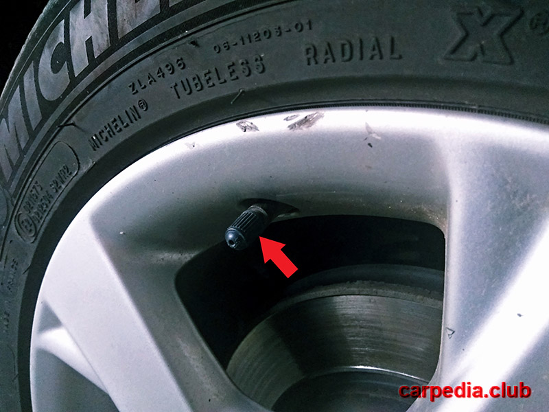 Отвернуть колпачок от вентиля для проверки давления в колесах на автомобиле Toyota Auris