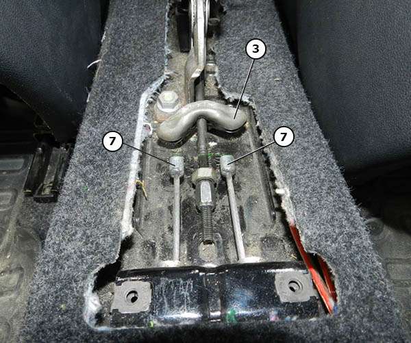 Отсоединение наконечников тросов от уравнителя механизма ручного тормоза автомобиля Skoda Fabia I