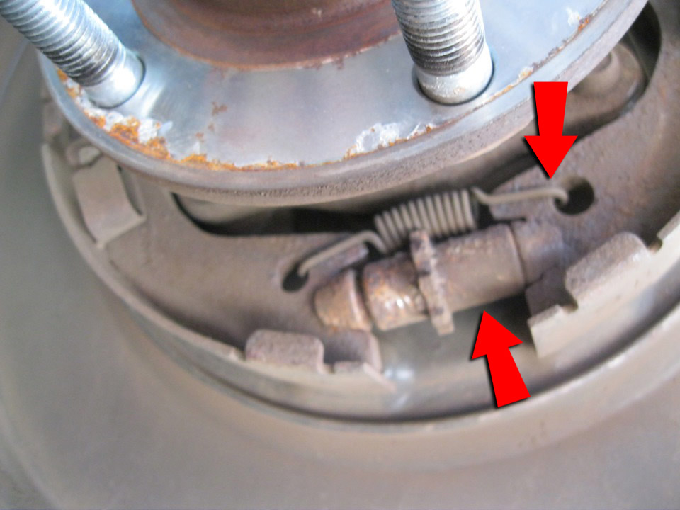 Снять нижнюю стяжную пружину колодок стояночного тормоза на автомобиле Hyundai Santa Fe CM 2006-2012