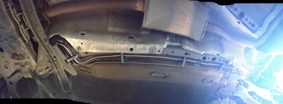 Откручивание гаек крепления термоэкрана основного глушителя к хомуту крепления топливного бака Ford Focus 2