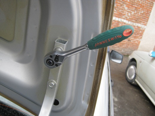 Откручивание болта крепления крышки багажника к петли кузова Лада Гранта (ВАЗ 2190)