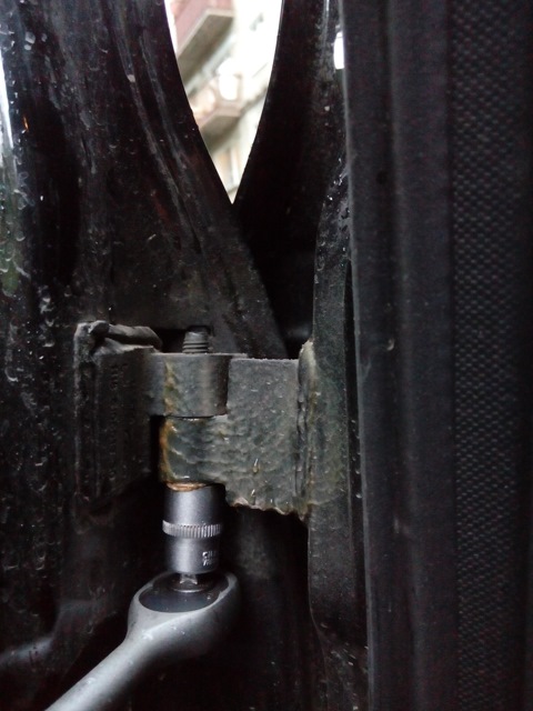 Откручивание болта крепления передней двери к верхней петле кузова Лада Гранта (ВАЗ 2190)