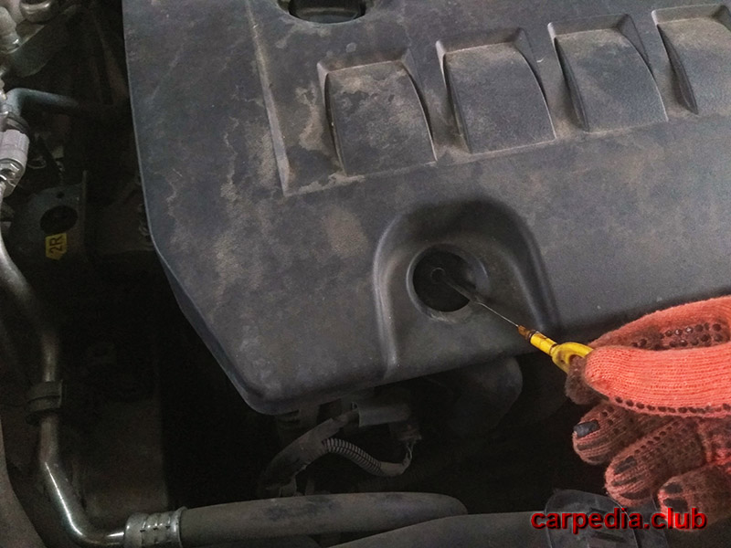 Ввод щупа в двигатель для проверки уровня моторного масла Toyota Auris