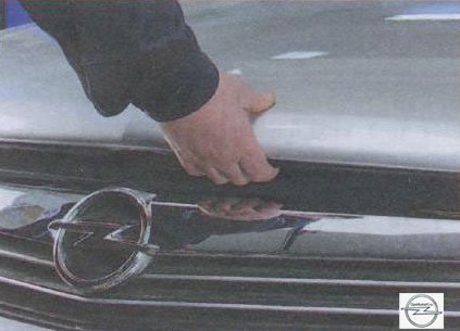 Нажатие на лапку предохранительного крючка на автомобиле Opel Astra