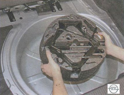 Извлечение ниши с инструментами из багажника на автомобиле Opel Astra