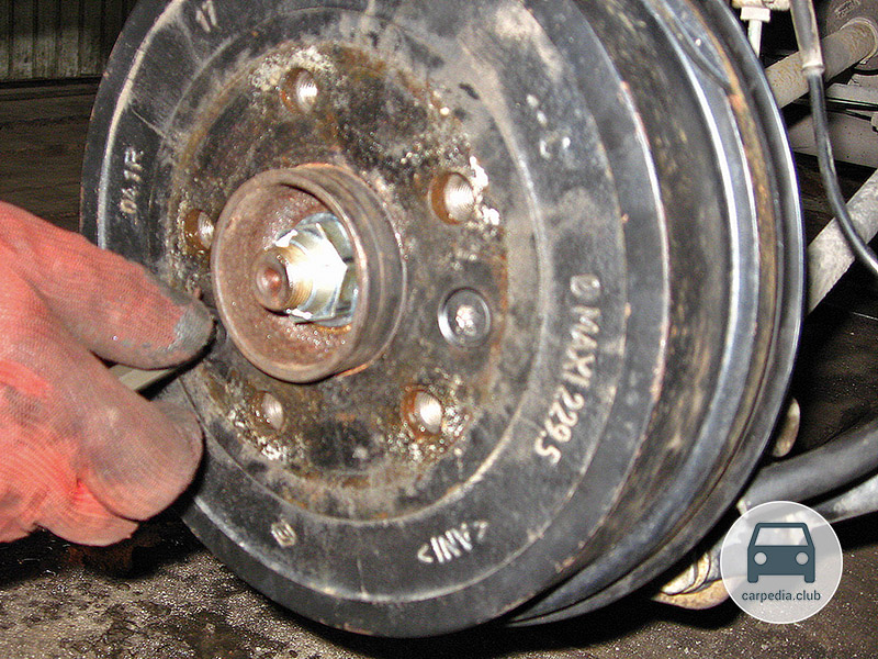 Отворачивание винта крепления тормозного барабана к ступице правого заднего колеса Renault Duster