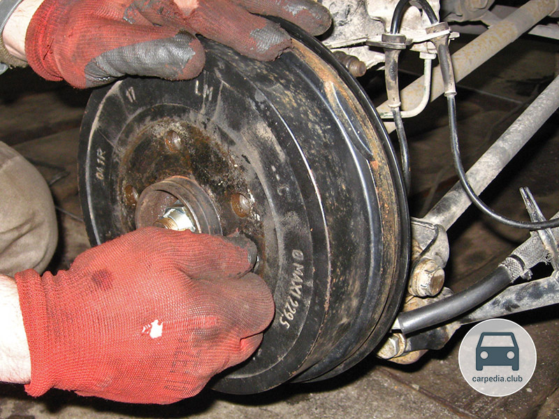 Отворачивание винта крепления тормозного барабана к ступице правого заднего колеса Renault Duster