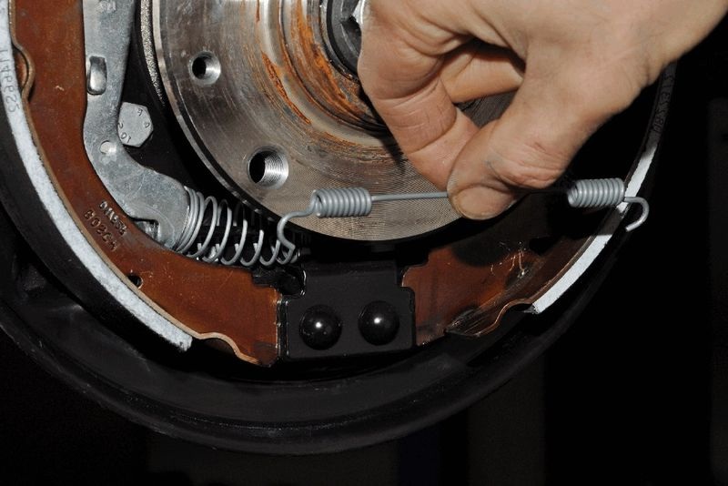 Снятие нижней стяжной пружины заднего тормозного механизма Renault Duster