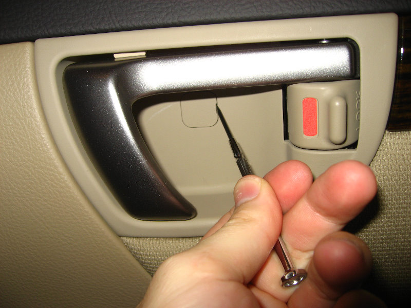 Откинуть заглушку крепления крышки внутренней ручки двери Hyundai Santa Fe CM 2006-2012