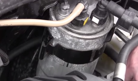 Откручиваем гайку крепления на кронштейне топливного фильтра Fiat Doblo