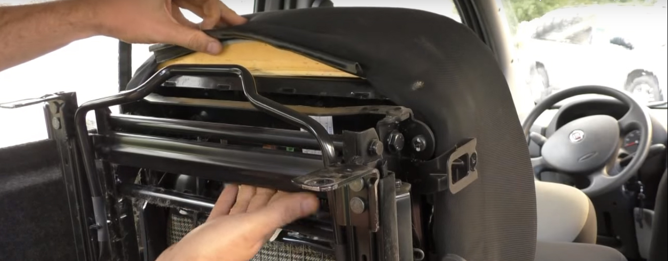 Отсоединяем пластиковые защелки крепления обивки с задней части сидения Fiat Doblo