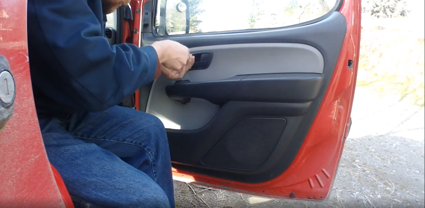 Откручиваем крестовой отверткой болт крепления внутри рычага открытия двери Fiat Doblo