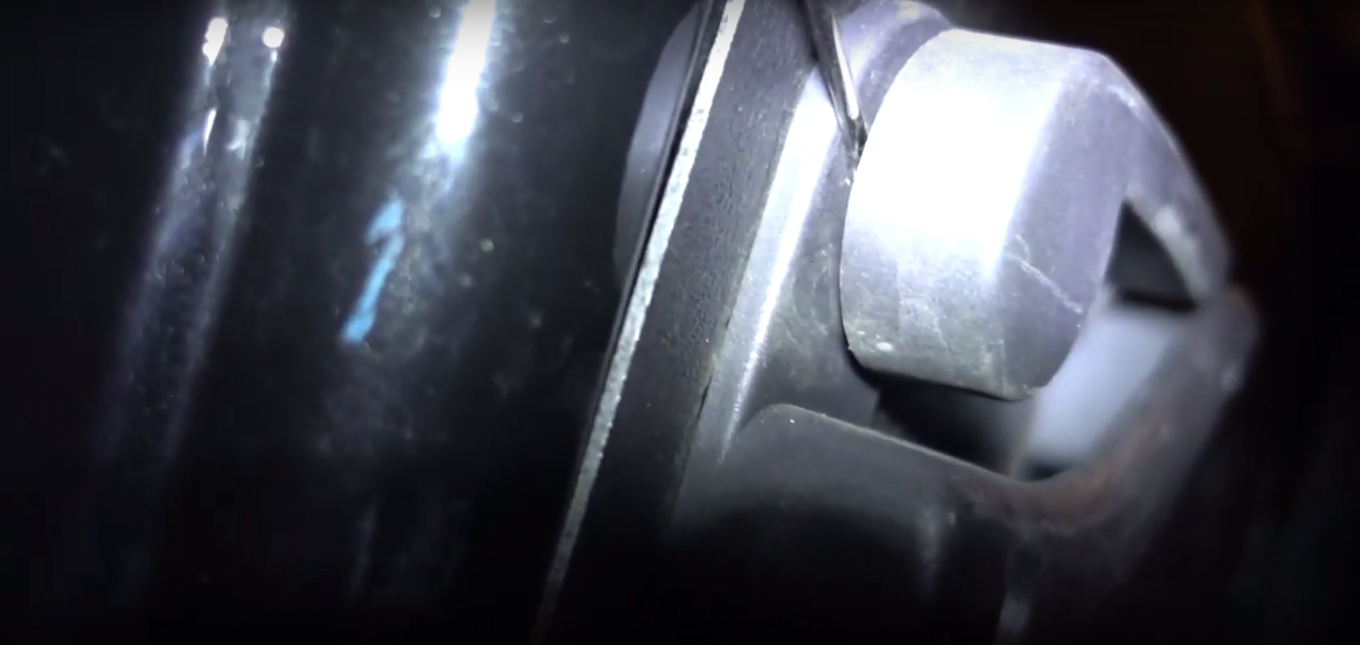 Плоской отверткой поддеваем скобу крепления внутри салонной ручки двери багажного отделения Fiat Doblo