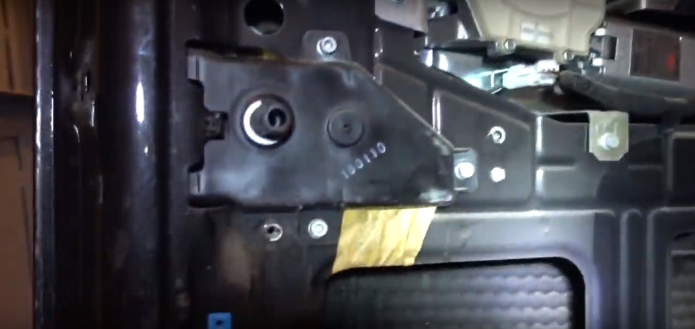 Вид на металлический защитный блок замка открытия и закрытия двери багажного отделения Fiat Doblo
