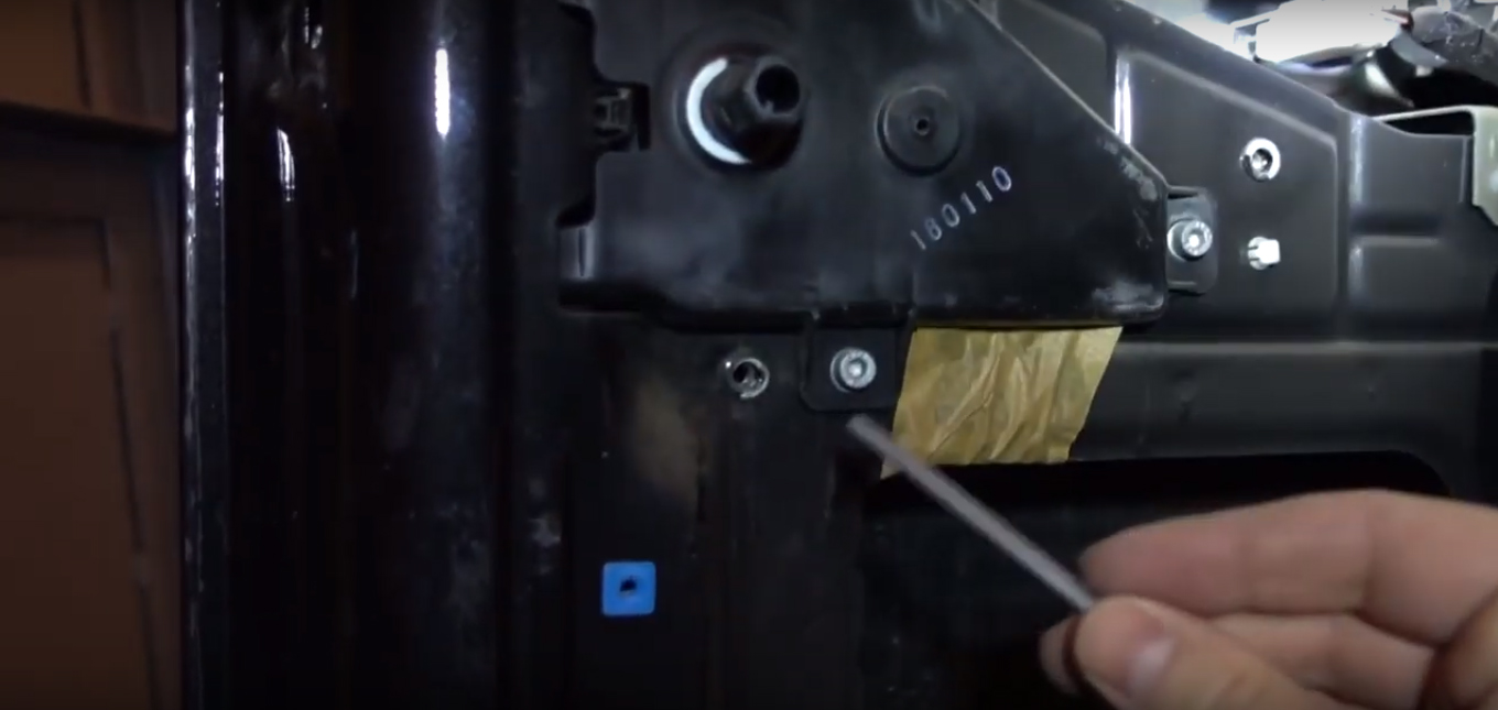 Откручиваем, шестигранником на 4 мм, первый болт крепления металлической защиты механизма замка двери багажного отделения Fiat Doblo